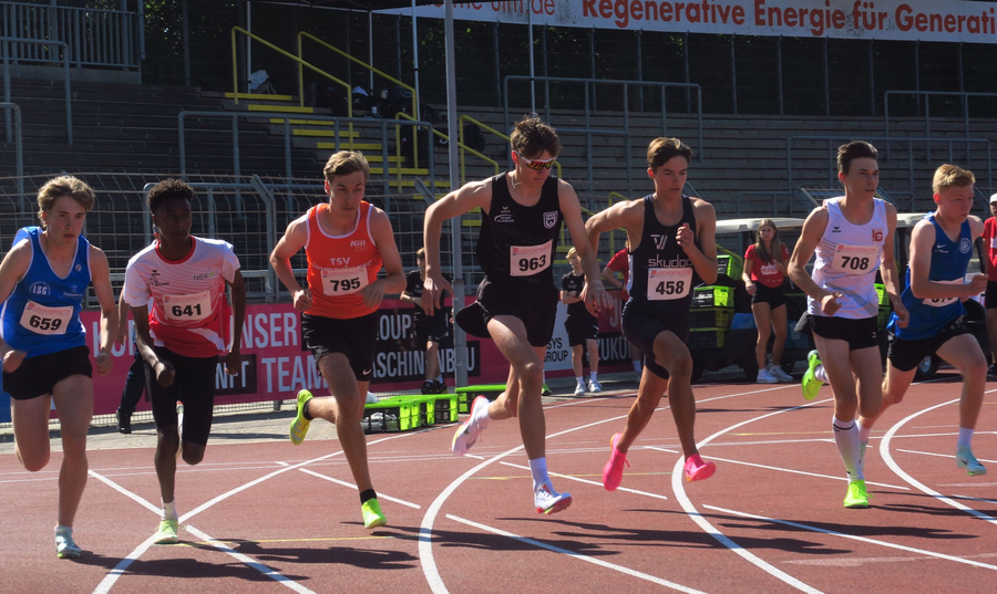 Mehrere junge Läufer starten Sprint auf roter Leichtathletikbahn
