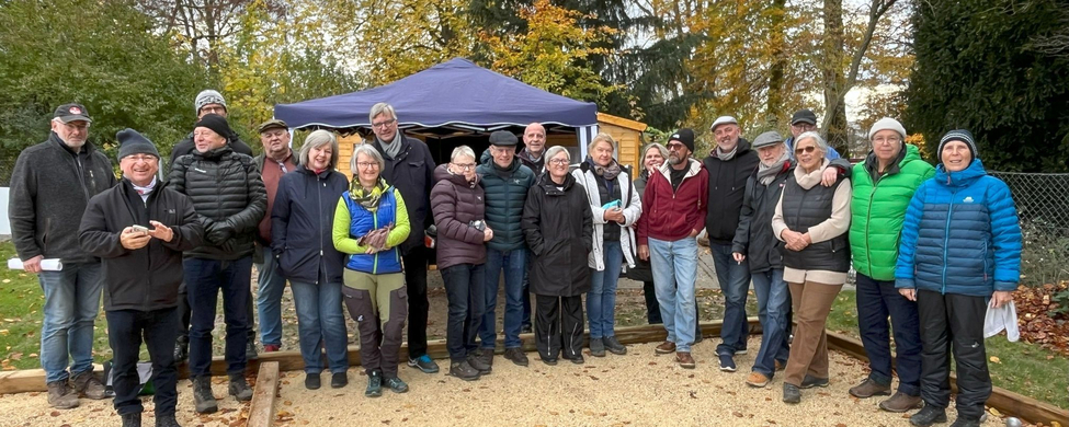 Gruppe von etwa 22 Personen auf Bouleplatz vor Pavillon