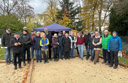 Gruppe von etwa 22 Personen auf Bouleplatz vor Pavillon