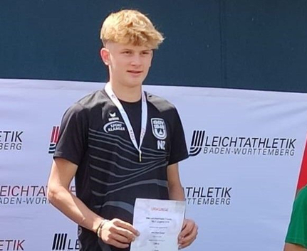 Fünf Medaillen und Gold im Weitsprung: Nils Zeller U16-Leichtathlet mit Medaille und Urkunde vor Leichtathletik-Banner