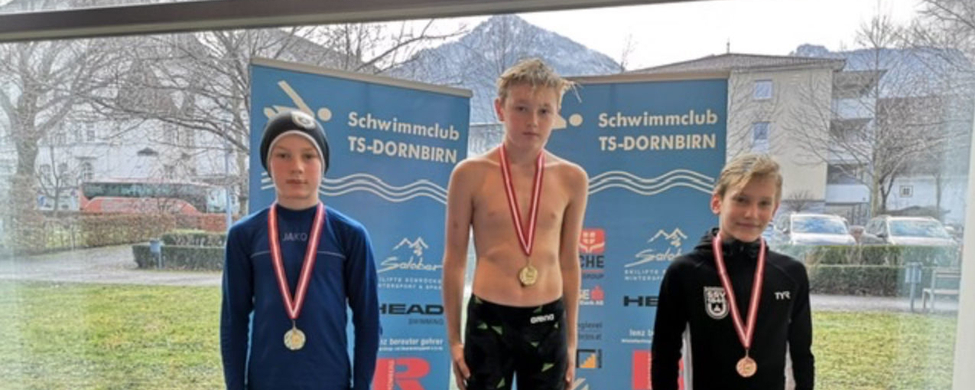 Drei jugendliche Schwimmer auf Siegertreppchen mit Medaillen Banner Schwimmclub TS-DORNBIRN