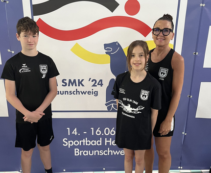 Zwei junge SSV Ulm Schwimmer und Trainerin vor Banner