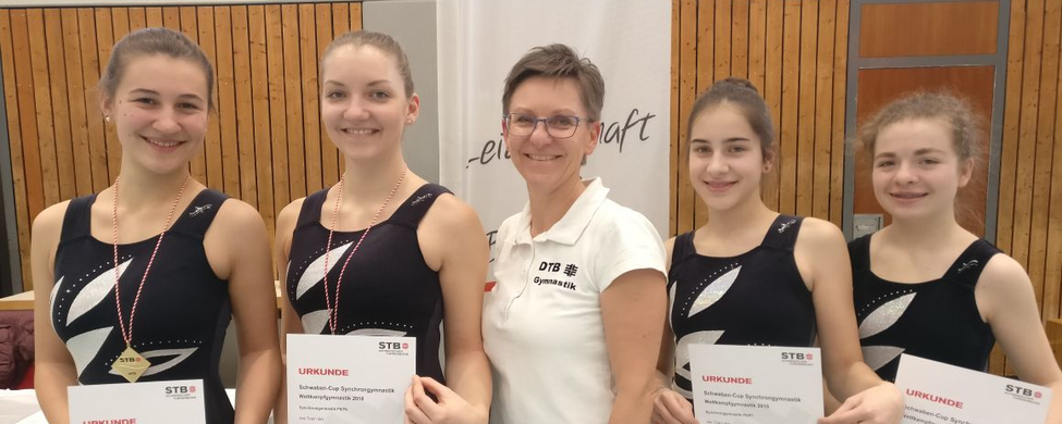 Vier Gymnastinnen mit Urkunden und Trainerin vor STB-Banner