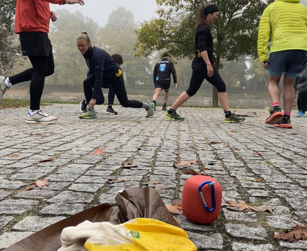 Gelbe Handschuhe und roter Lautsprecher auf Kopfsteinpflaster, Sportler dehnen in der Friedrichsau