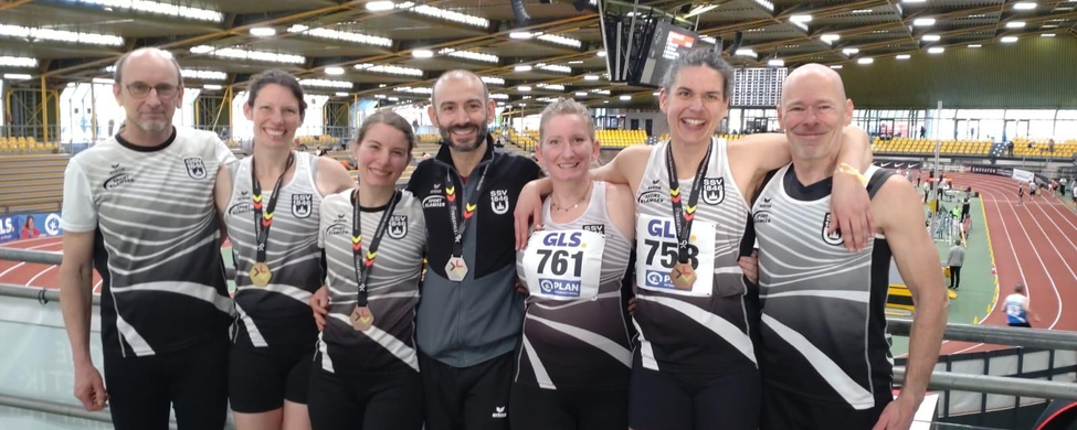 Sieben Athletinnen und Athleten in Teamtrikots mit Medaillen GLS 761 GLS 758