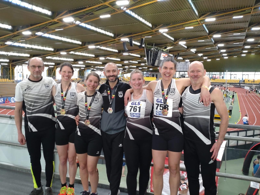 Sieben Athletinnen und Athleten in Teamtrikots mit Medaillen GLS 761 GLS 758