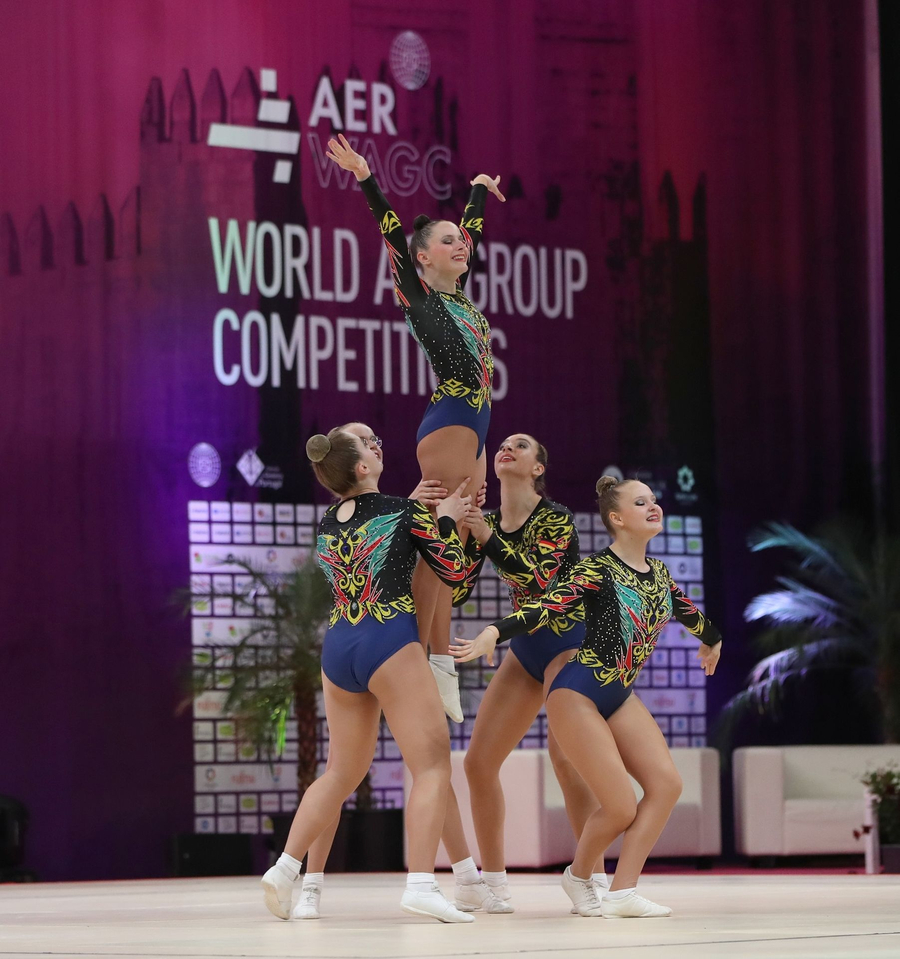 Vier Aerobic-Athletinnen in Hebefigur während Wettkampf