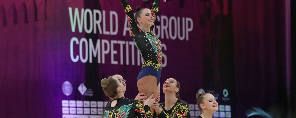 Vier Aerobic-Athletinnen in Hebefigur während Wettkampf