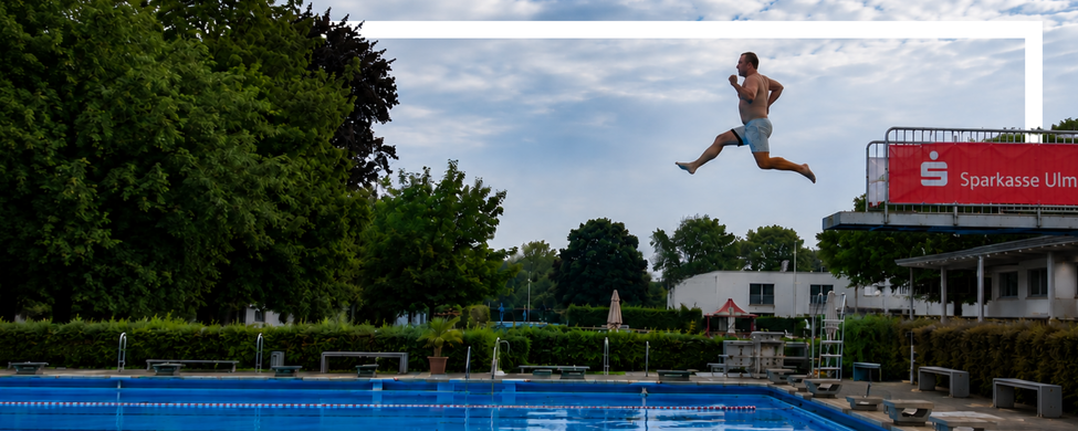 Mann springt vom 3-m-Sprungturm im SSV Ulm 1846 e.V. Freibad