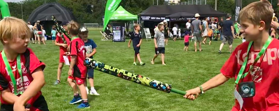 Zwei Kinder in roten Trikots duellieren mit Schaumstoffschwertern SUNFLEX