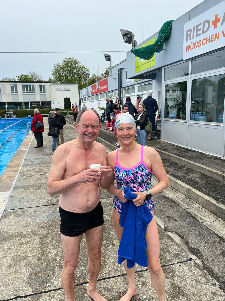 Zwei ältere Schwimmer in Badebekleidung am Beckenrand beim Anschwimmen